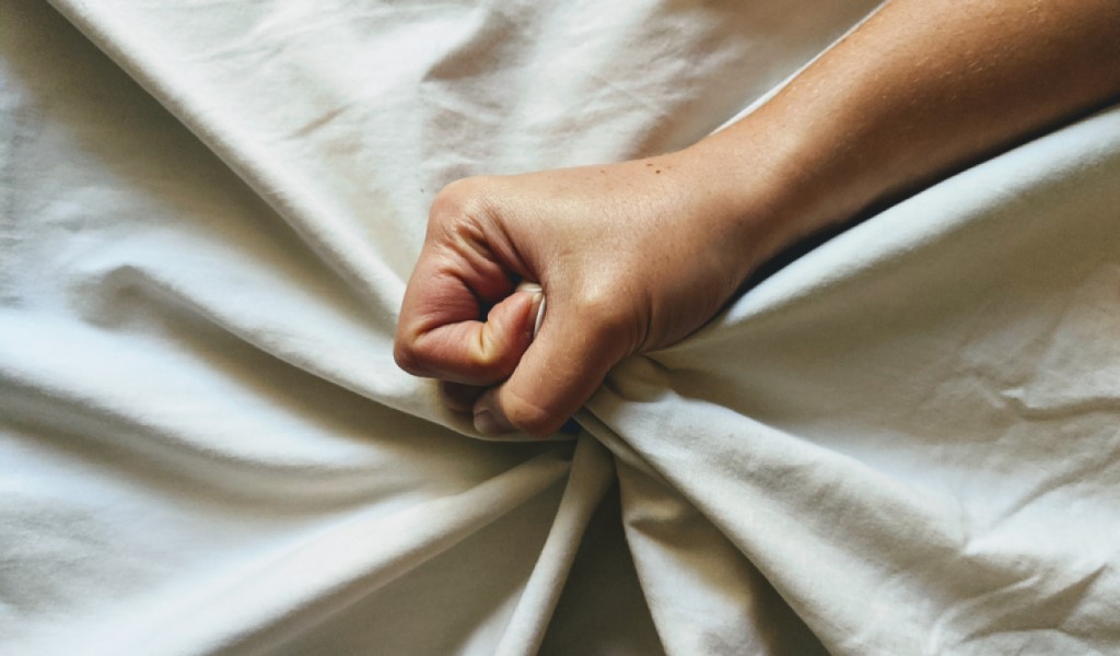 Hand gripping a white sheet
