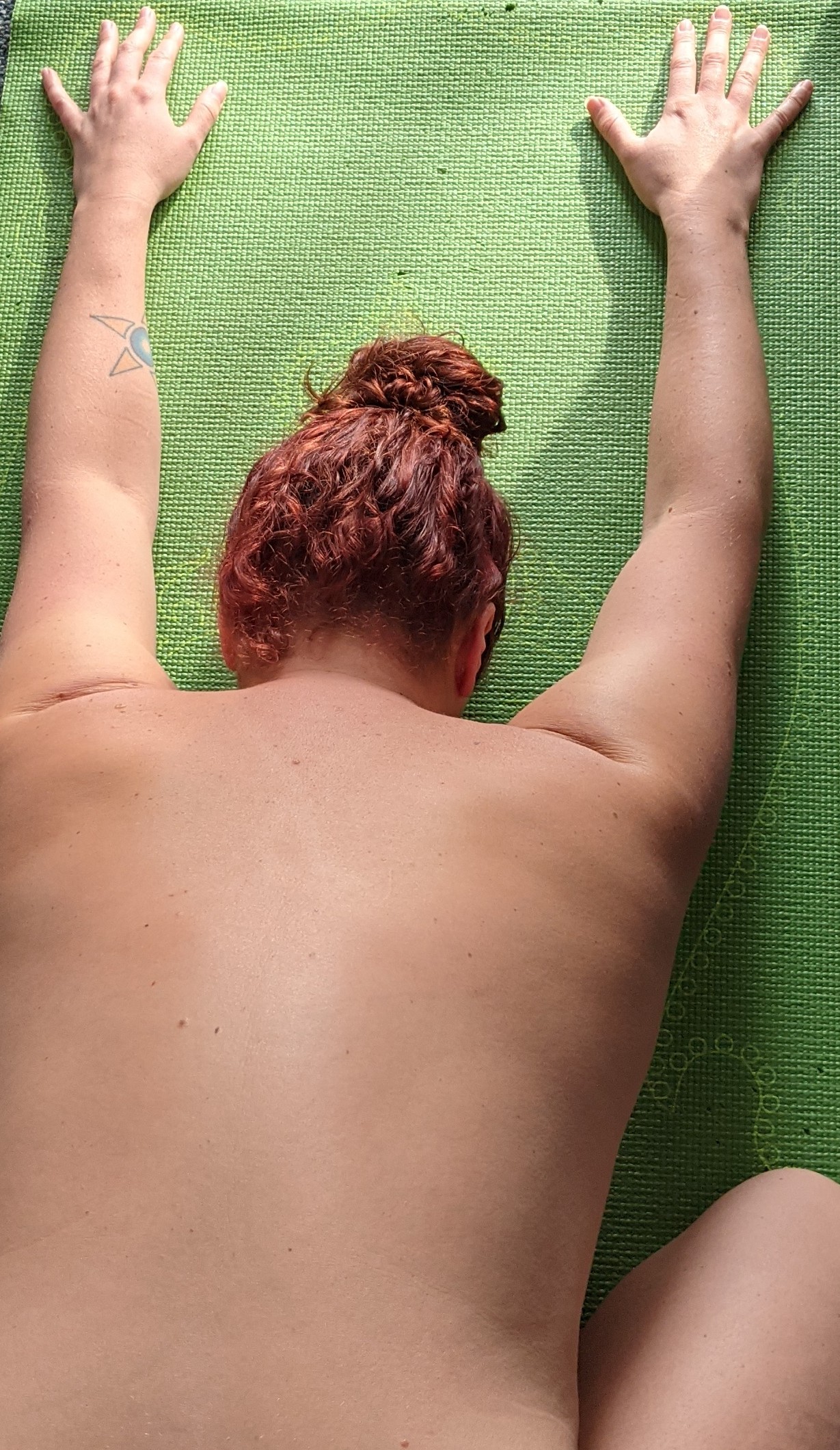 Nikki in Child's pose on a yoga mat