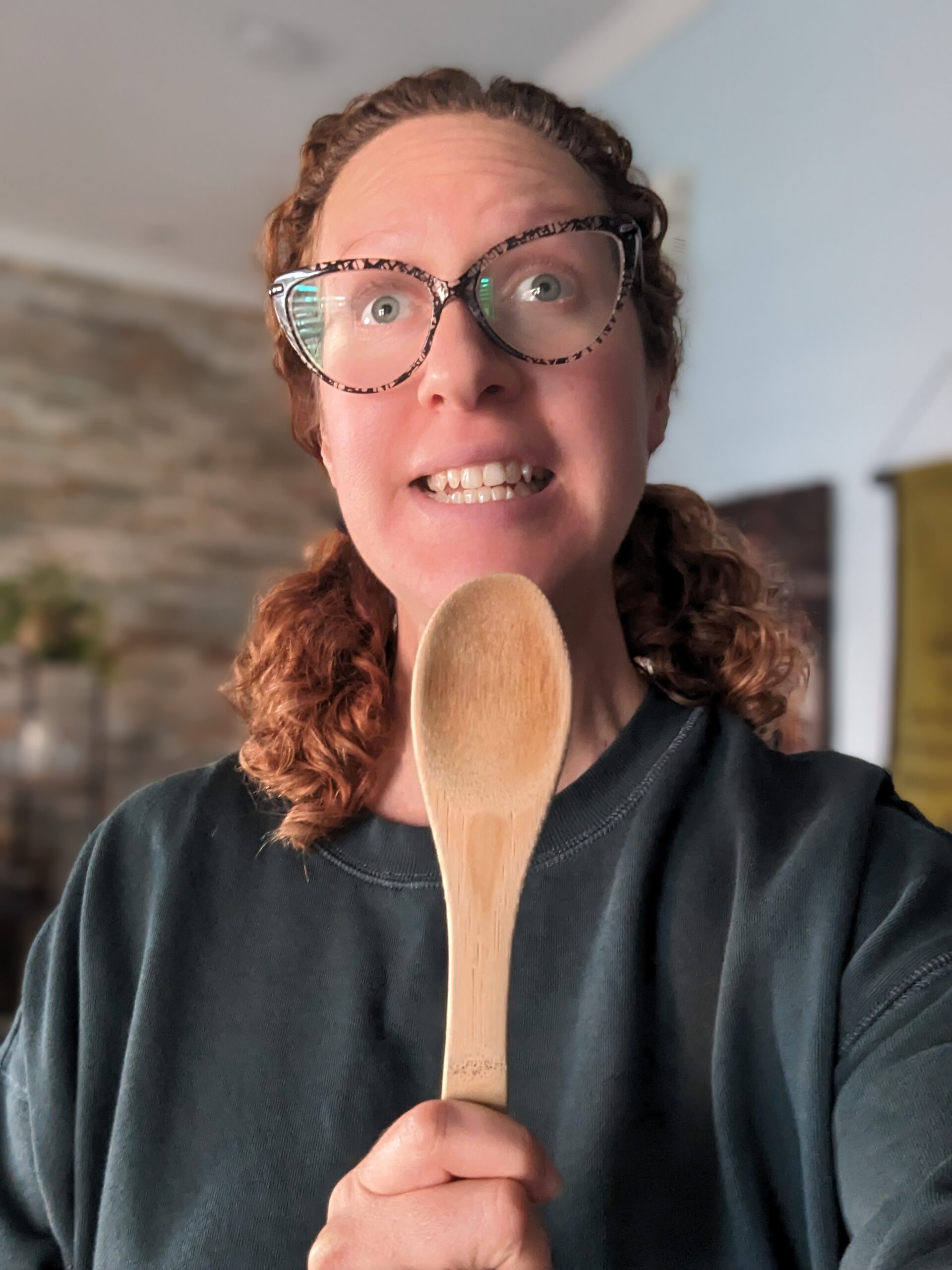 Nikki looks silly as she uses a wooden spoon as a pretend microphone.